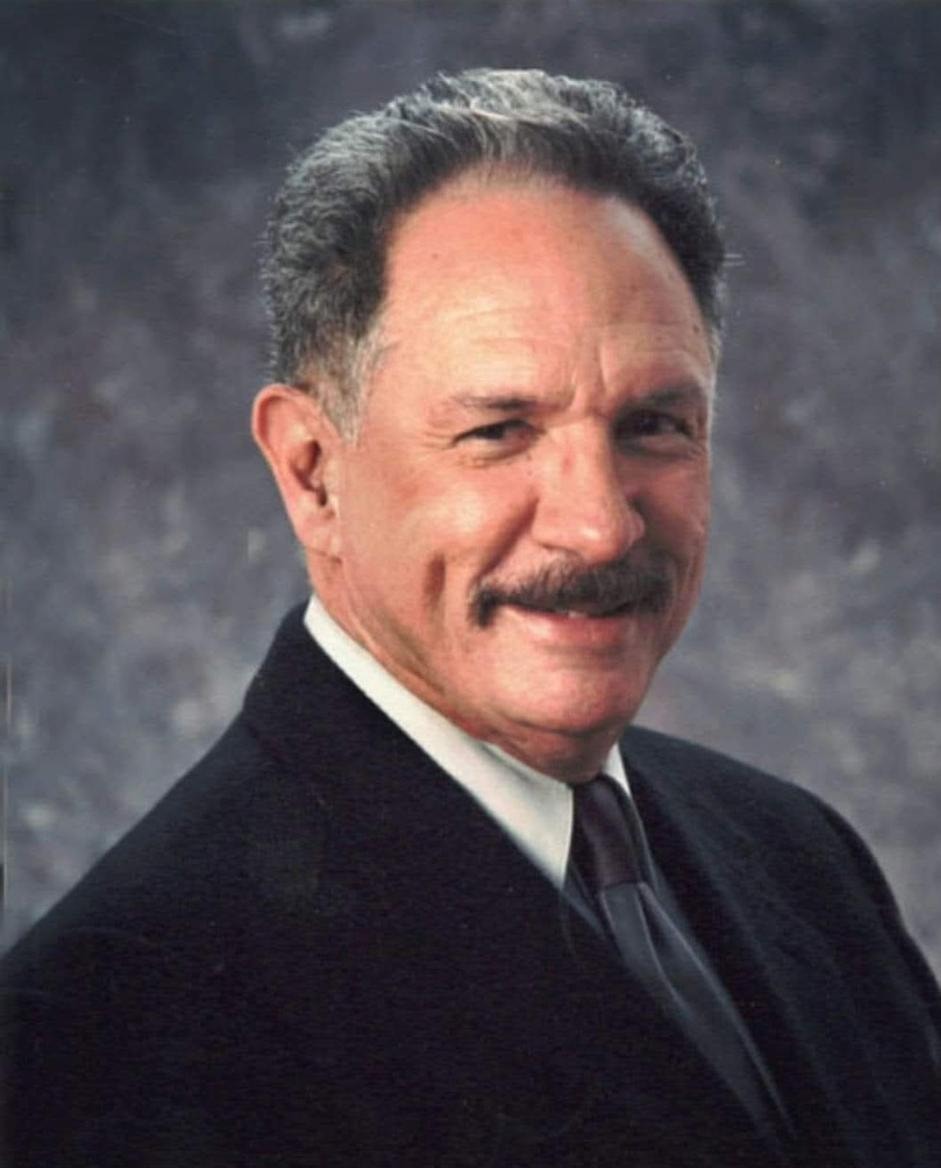 Professional portrait of a man in a dark suit and tie