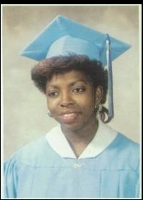 Graduate in light blue cap and gown portrait