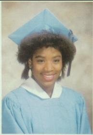 Young woman in light blue cap and gown graduation portrait