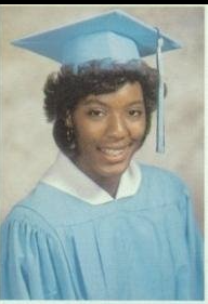 Young woman in light blue cap and gown graduation portrait