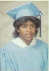 Young woman in light blue cap and gown graduation portrait