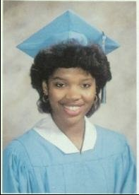 Young woman in light blue cap and gown graduation portrait