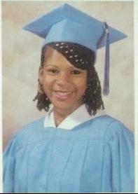 Young woman in light blue cap and gown graduation portrait