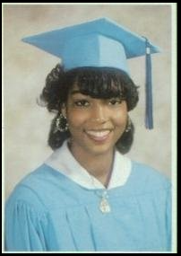 Young woman in light blue cap and gown graduation portrait