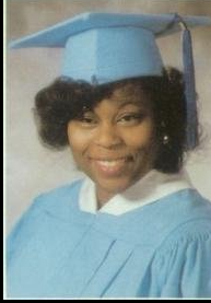 Young woman in light blue cap and gown graduation portrait
