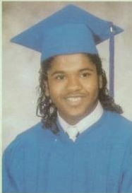 Young man in blue cap and gown graduation portrait