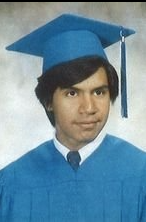 Young man in blue cap and gown graduation portrait