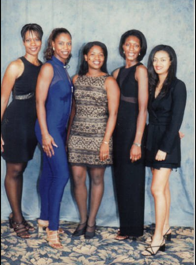 Five women posing together at a reunion event