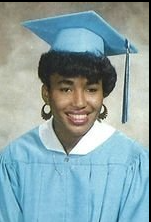 Young woman in light blue cap and gown graduation portrait