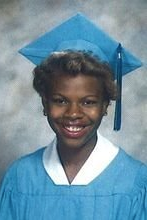 Young woman in light blue cap and gown graduation portrait