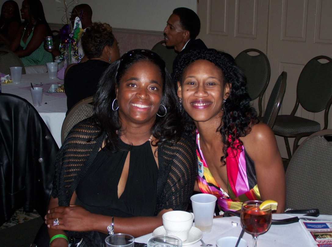 Two women smiling together at a reunion dinner event